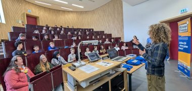 Eine Frau erklärt einer Schulklasse des BZM etwas über das Projekt "Mitmachen ist Ehrensache". Die Kinder hören gespannt zu