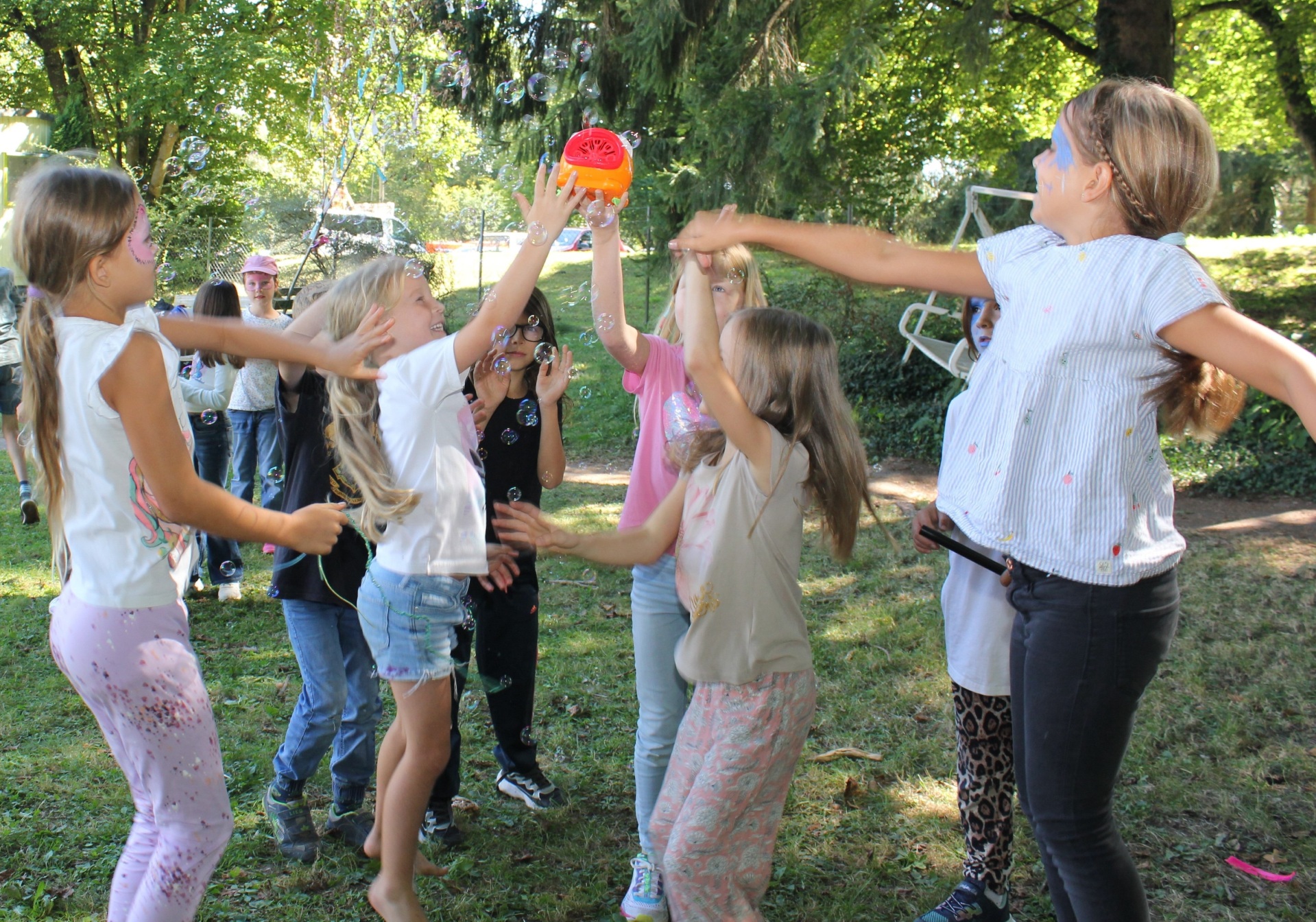 Mehrere Kinder Tanzen mit Seifenblasen und geschminkten Gesichtern