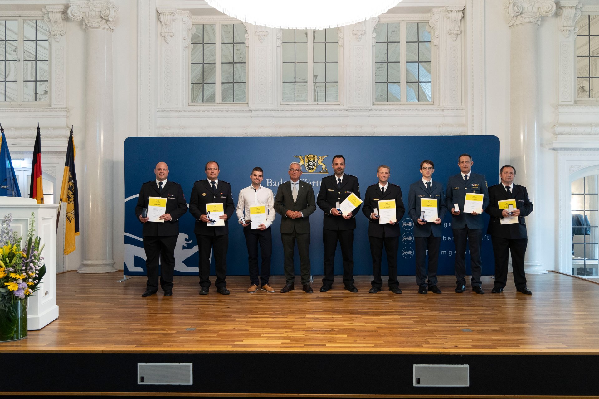 Verleihung der Bevölkerungsschutz-Einsatzmedaille Unwetter 2024 Feuerwehrleute auf einer Bühne. Verleihung der Auszeichnung durch den Minister für Inneres Thomas Strobl.