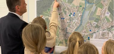 Bürgermeister Georg Schellinger zeigt den Gemeindedetektiven Orte auf der Karte Meckenbeurens