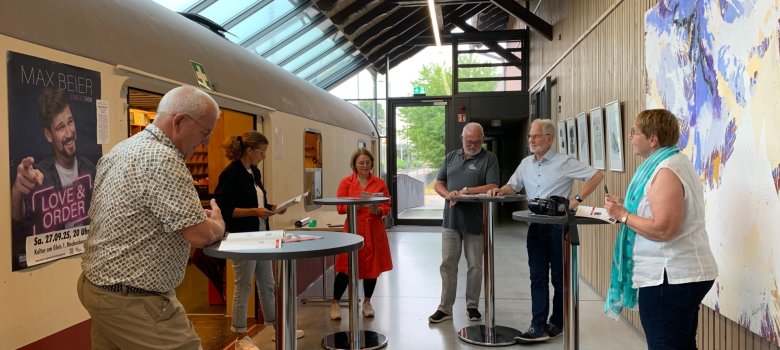 Mehrere Personen des Kulturkreises stehen an Stehtischen zusammen