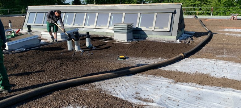 Substrate für bessere Grünbepflanzung  werden auf dem Dach der Kita Hegenberg verteilt