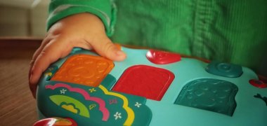 Ein kleines Kindergartenkind nimmt einen Spielklotz in die Hand