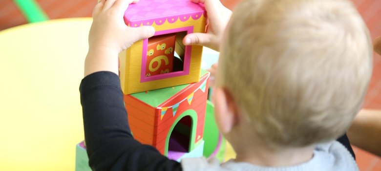 Ein kleines Baby baut einen Turm aus Spielklötzen