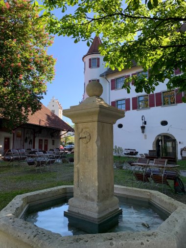 Schlossbrunnen Brochenzell mit Schloss und blühenden Kastatanienbäumen