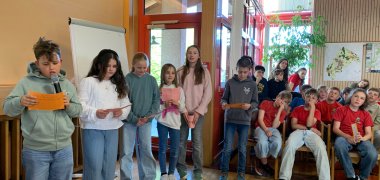 Grundschüler zum Teil in roten T Shirts im Großen Sitzungssaal der Gemeinde tragen etwas vor