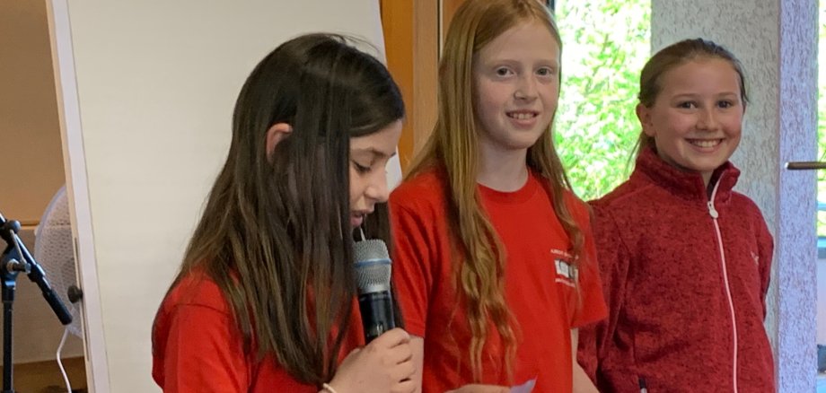 Grundschüler zum Teil in roten T Shirts im Großen Sitzungssaal der Gemeinde tragen etwas vor