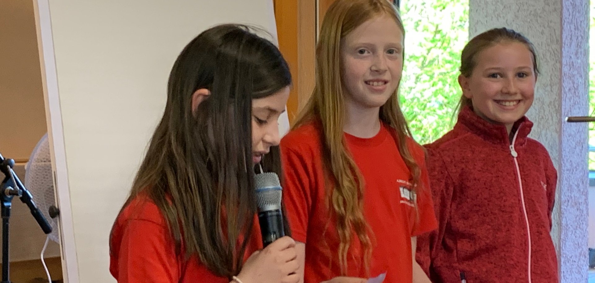 Grundschüler zum Teil in roten T Shirts im Großen Sitzungssaal der Gemeinde tragen etwas vor