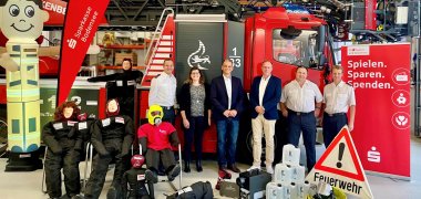 Gruppenbild der Feuerwehrleute anlässlich der Spendenübergabe vor Feuerwehrauto