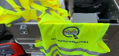 Blechkiste mit gelber Warnweste und weiterem Inhalt des Ausstattungssets Notfalltreffpunkt