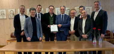 Gruppenbild nur Männer im Trauzimmer der Gemeinde Meckenbeuren vor Holzwand