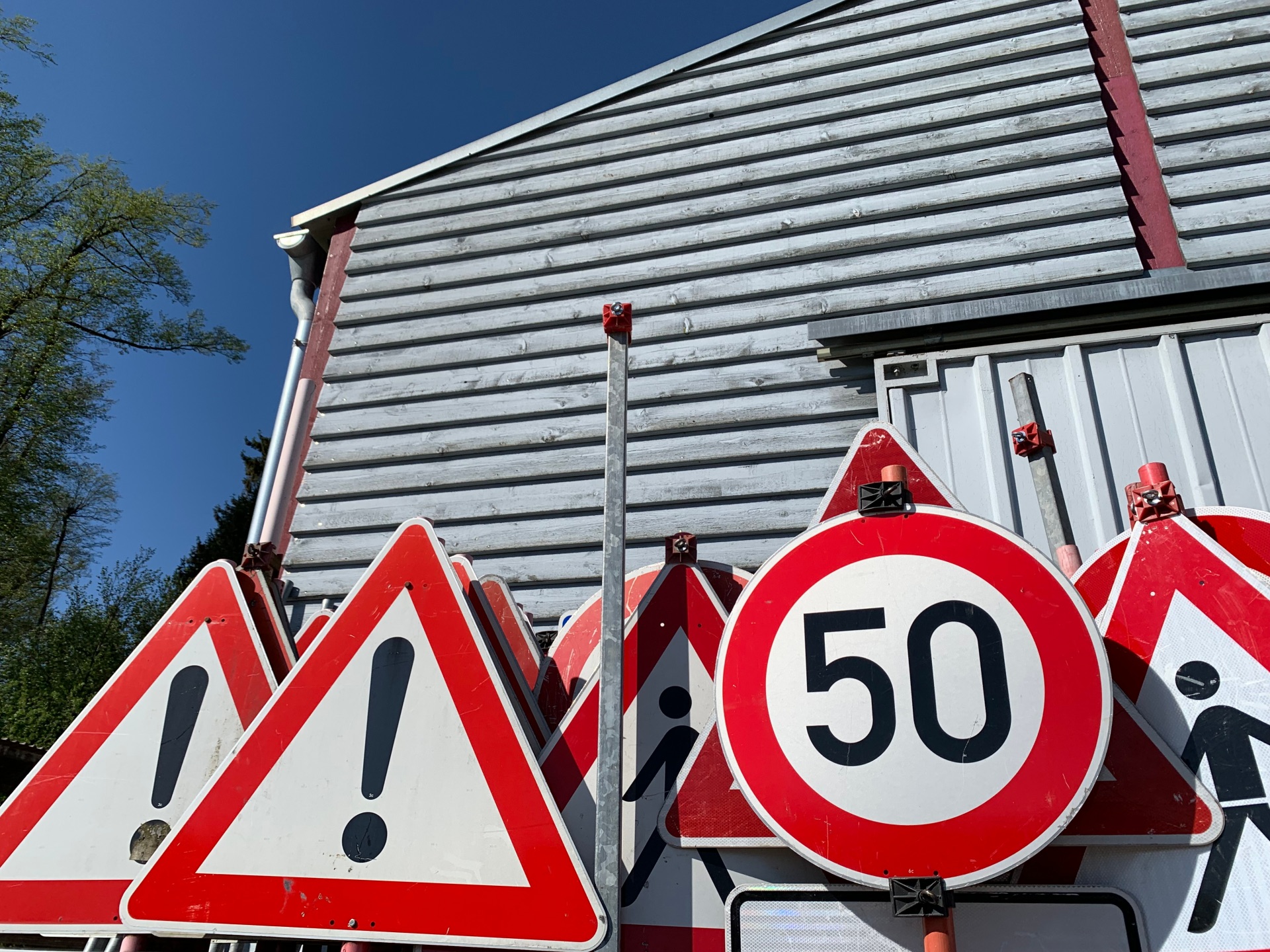 verschiedene rotweiße Straßenschilder zu Bauarbeiten und Geschwindigkeitsbegrenzungen