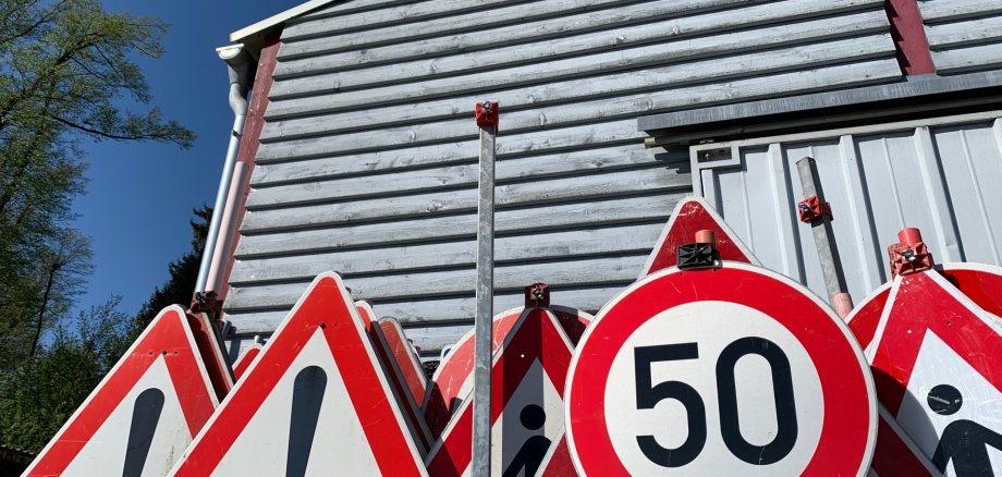 verschiedene rotweiße Straßenschilder zu Bauarbeiten und Geschwindigkeitsbegrenzungen