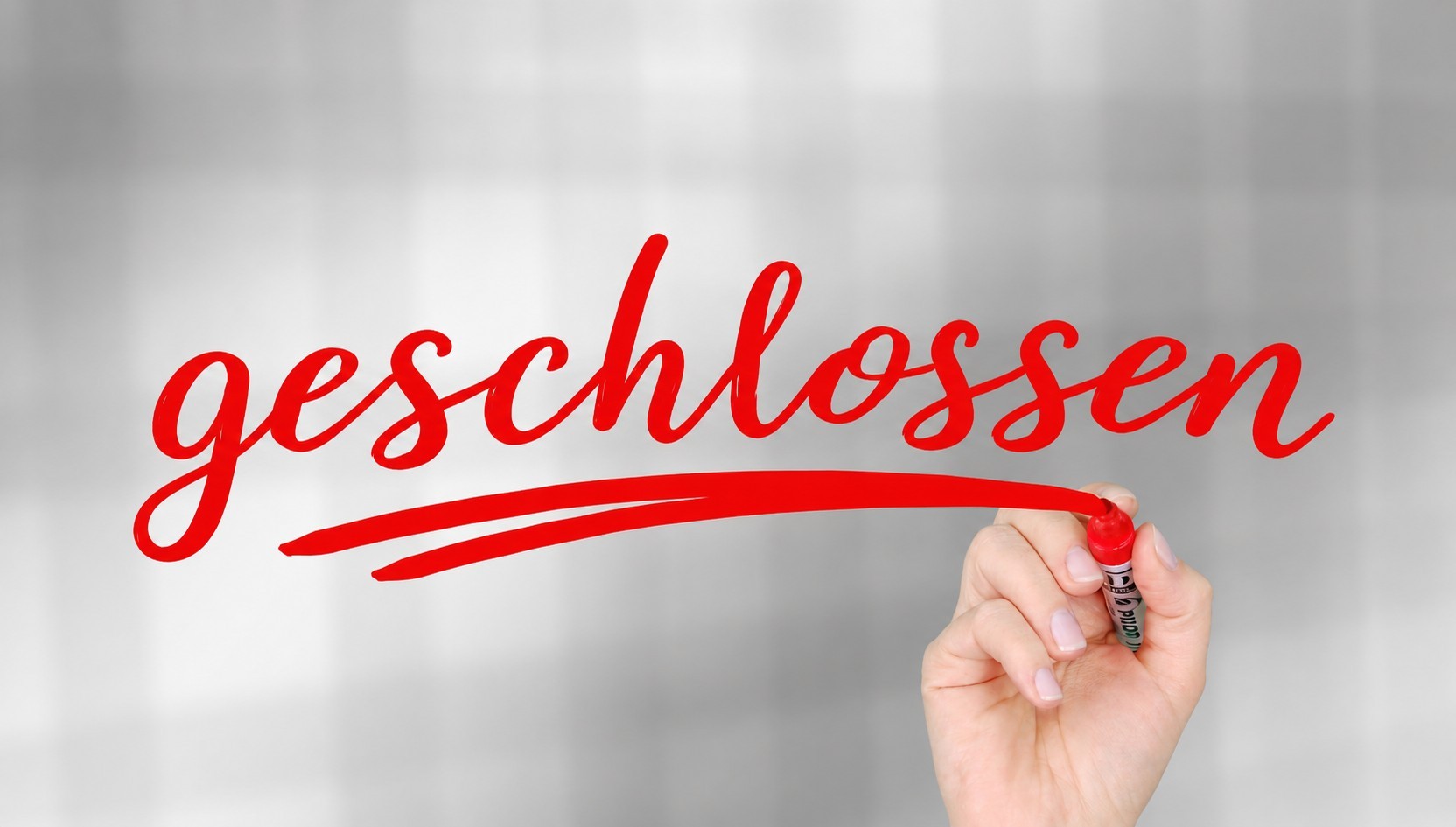 roter Schriftzug geschlossen, der von einer Hand gemalt wird