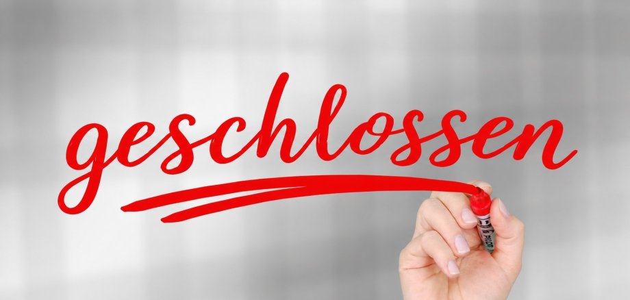 roter Schriftzug geschlossen, der von einer Hand gemalt wird