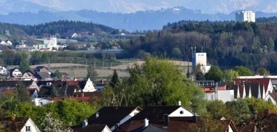 Luftaufnahme vom Ort mit Bergen und Kirche im Hintergrund